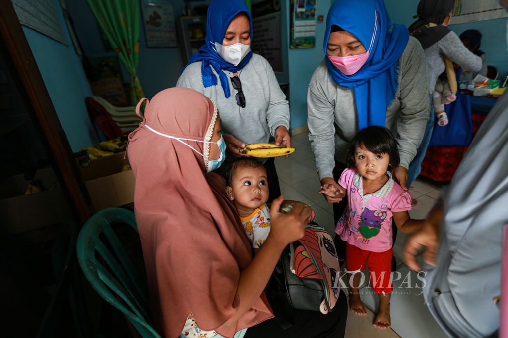 Kader posyandu memberikan pisang kepada anak balita yang telah menjalani pemeriksaan di Posyandu Mawar di RW 04 Kampung Bulak Wareng, Larangan Selatan, Larangan, Kota Tangerang Banten, Jumat (8/4/2022).