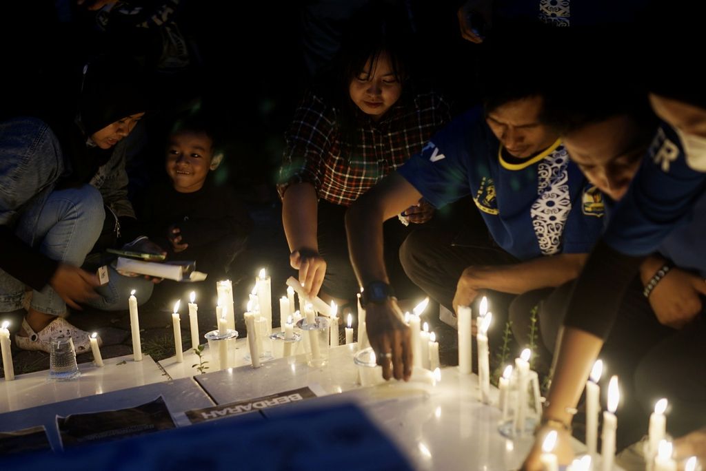 Pencinta sepak bola meletakkan lilin dalam doa bersama di Kota Balikpapan, Kalimantan Timur, Senin (3/10/2022) malam. Ratusan pencinta sepak bola berkumpul dan berdoa bersama bagi ratusan korban akibat tragedi di Stadion Kanjuruhan, Malang, Jawa Timur.
