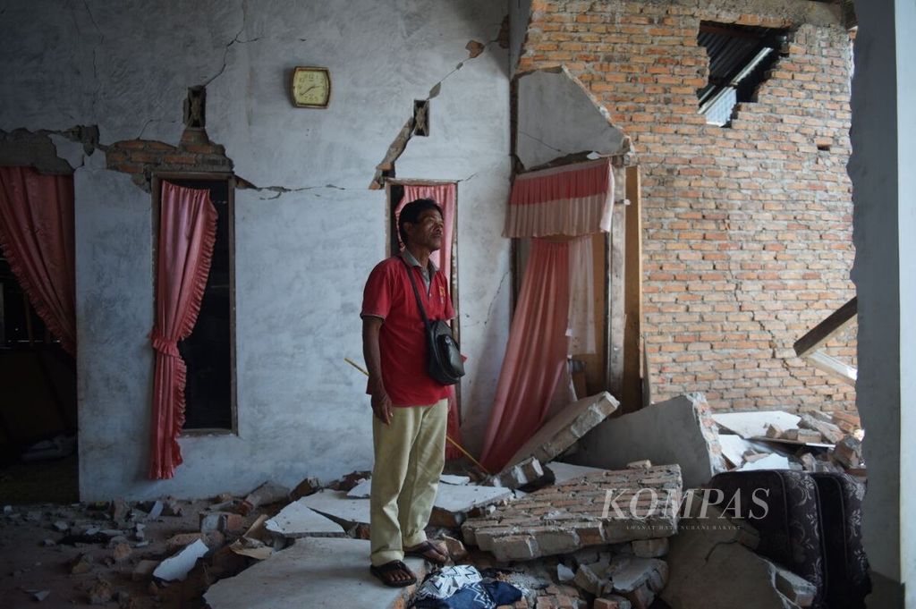 Romli (52) Hendra (50) menunjukkan kondisi rumahnya yang rusak di Nagari Kajai, Kecamatan Talamau, Kabupaten Pasaman Barat, Sumatera Barat, Sabtu (26/2/2022). Pasaman Barat dan sekitarnya dilanda gempa bermagnitudo 6,1 pada 25 Februari lalu.