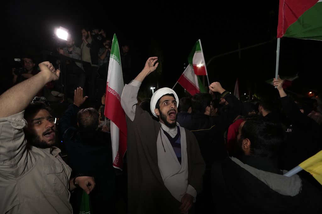 Pengunjuk rasa menyerukan slogan-slogan saat berkumpul menyatakan dukungan atas serangan Iran ke Israel di depan Kedutaan Besar Inggris di Teheran, Iran, 14 April 2024. 