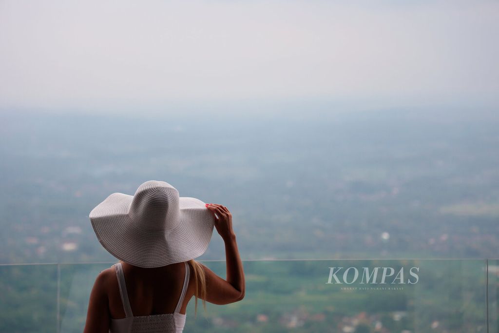 Pengunjung menikmati pemandangan sore dengan latar hamparan sawah, perdesaan, dan beberapa gunung yang tampak dari Plataran Shailendra Borobudur, Desa Candirejo, Kecamatan Borobudur, Kabupaten Magelang, Jawa Tengah, Jumat (22/3/2024).