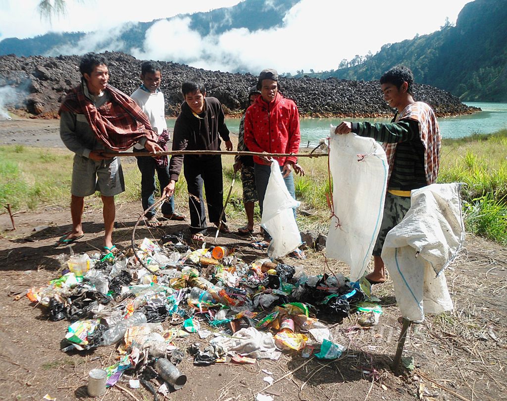 Para porter dan pemandu wisata di kawasan Gunung Rinjani, Lombok, Nusa Tenggara Barat, tengah membersihkan kawasan itu dari tumpukan sampah, November 2013.
