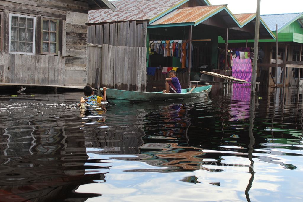 Warga Katingan Hilir menggunakan kelotok untuk melewati banjir di Kabupaten Katingan, Kalimantan Tengah, Rabu (14/9/2022).