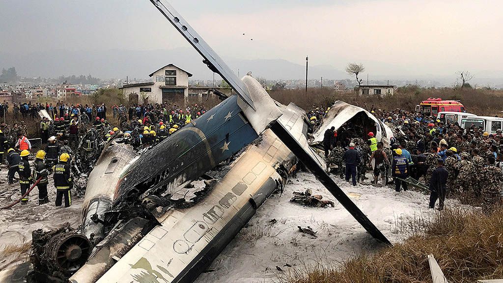 Puing pesawat yang mengalami kecelakaan di dekat Bandar Udara Internasional Tribhuvan, Kathmandu, Nepal, Senin (12/3). 