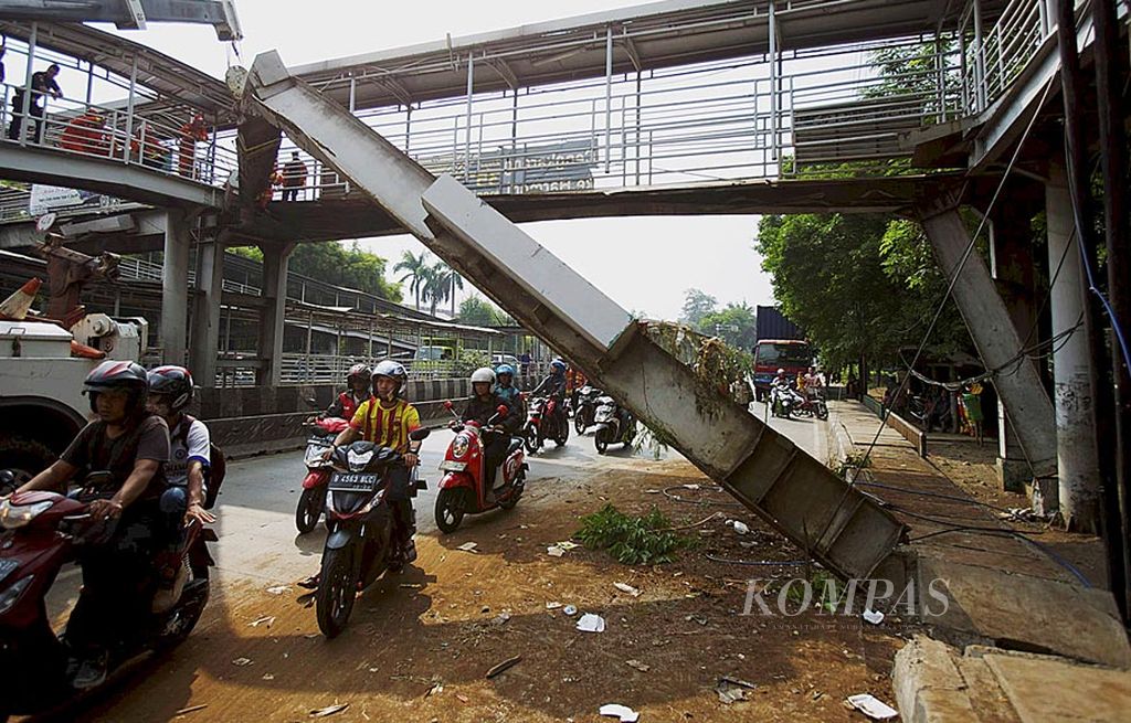 Petugas  memotong balok besi jembatan penyeberangan orang yang sebagian roboh tertabrak truk kontainer di Jalan Daan Mogot, Jakarta Barat, Sabtu (29/7).