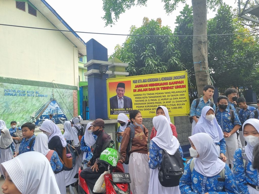Para siswa SMP Negeri 3 berdiri di depan papan berisi ajakan untuk tidak membuang sampah sembarangan, Jalan Raden Patah, Ciledug, Tangerang, Kamis (5/1/2023)