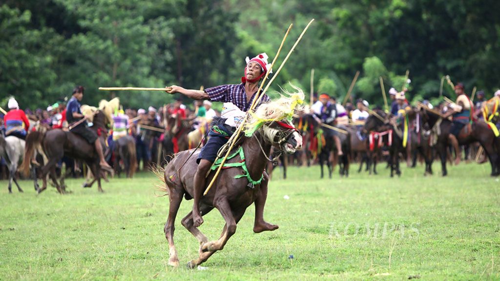 Peserta pasola melemparkan lembing kayu dari atas kuda pada acara puncak Festival Pasola di Desa Weihura, Kecamatan Wanukaka, Kabupaten Sumba Barat Daya, Nusa Tenggara Timur, Senin (20/3/2017).
