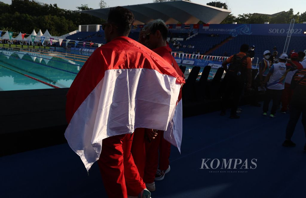 Salah satu atlet membawa bendera merah putih saat menunggu penyerahan medali cabang olahraga renang dalam ajang ASEAN Para Games 2022 di Kolam Renang GOR Jati Diri, Kota Semarang, Jawa Tengah, Senin (1/8/2022). Usaha keras para atlet mendapat ganjaran sepadan atau hasil tidak mengkhianati usaha”.