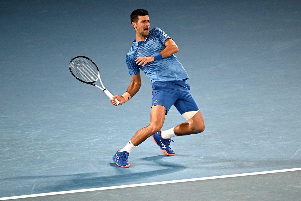 Novak Djokovic menahan kesakitan saat memukul bola dari petenis Bulgaria, Grigor Dimitrov, pada laga babak ketiga Grand Slam Australia Terbuka di Melbourne, 21 Januari 2023. 