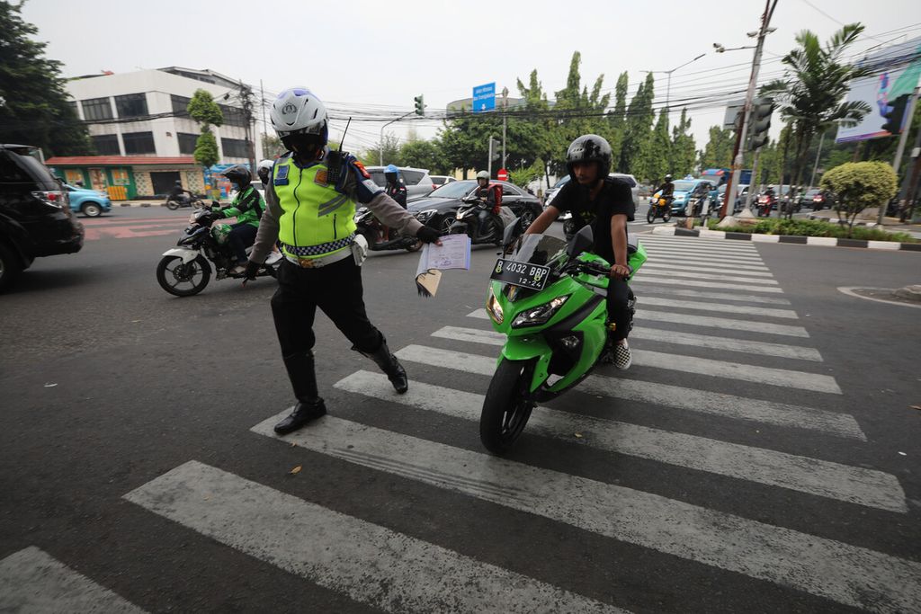 Polisi lalu lintas menghentikan pengendara sepeda motor yang melawan arus di persimpangan Permata Hijau, Jakarta Barat, Selasa (4/8/2020). 