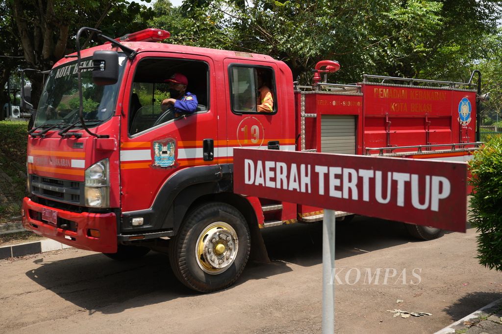 A fire truck passes through the entrance of the Gudang Munisi Daerah (Gudmurah) Kodam Jaya, which caught fire and exploded in Ciangsana Village, Gunung Putri District, Bogor Regency, West Java, on Sunday (31/3/2024).