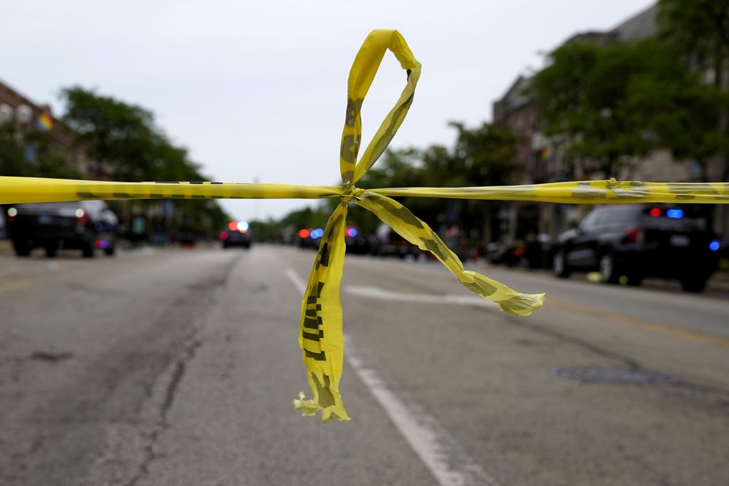 Garis polisi dipasang melintang menutup jalan Central Avenue and Green Bay  di Highland Park, sebuah permukiman di pinggiran Chicago, Senin (4/7/2022), setelah terjadi penembakan massal.