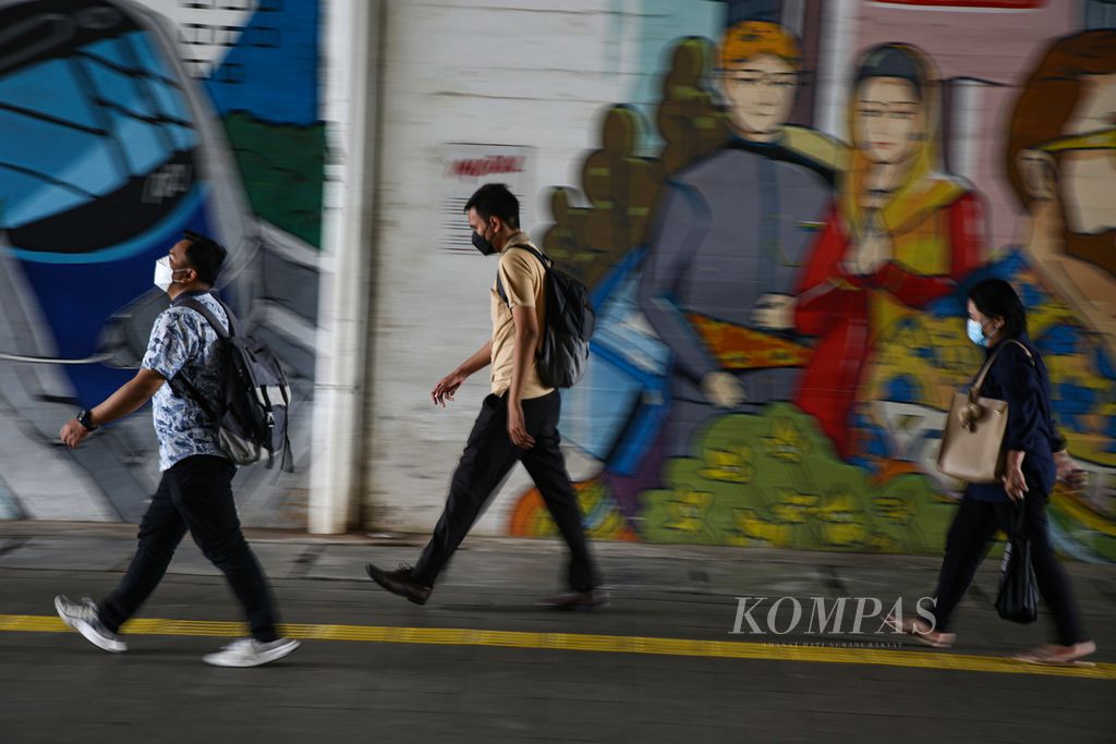 Para pekerja bergegas menuju tempat kerja mereka atau berganti moda transportasi dari stasiun Sudirman, Jakarta Pusat, Jumat (19/11/2021). Banyak para pekerja di Ibu Kota adalah generasi <i>sandwich </i>yang harus membagi penghasilannya untuk keluarga dan membantu ekonomi orangtua.