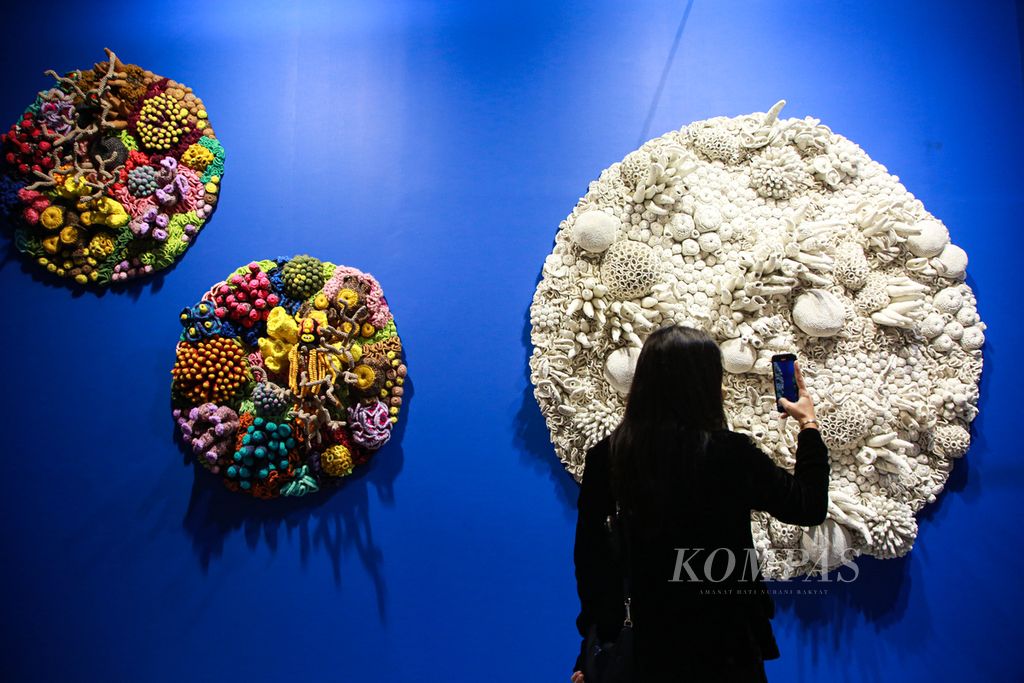 Pengunjung mengabadikan karya seni berjudul Coral Luna karya Mulyana dalam Art Jakarta 2022 di Jakarta Convention Center, Senayan, Jakarta, Jumat (26/8/2022). 