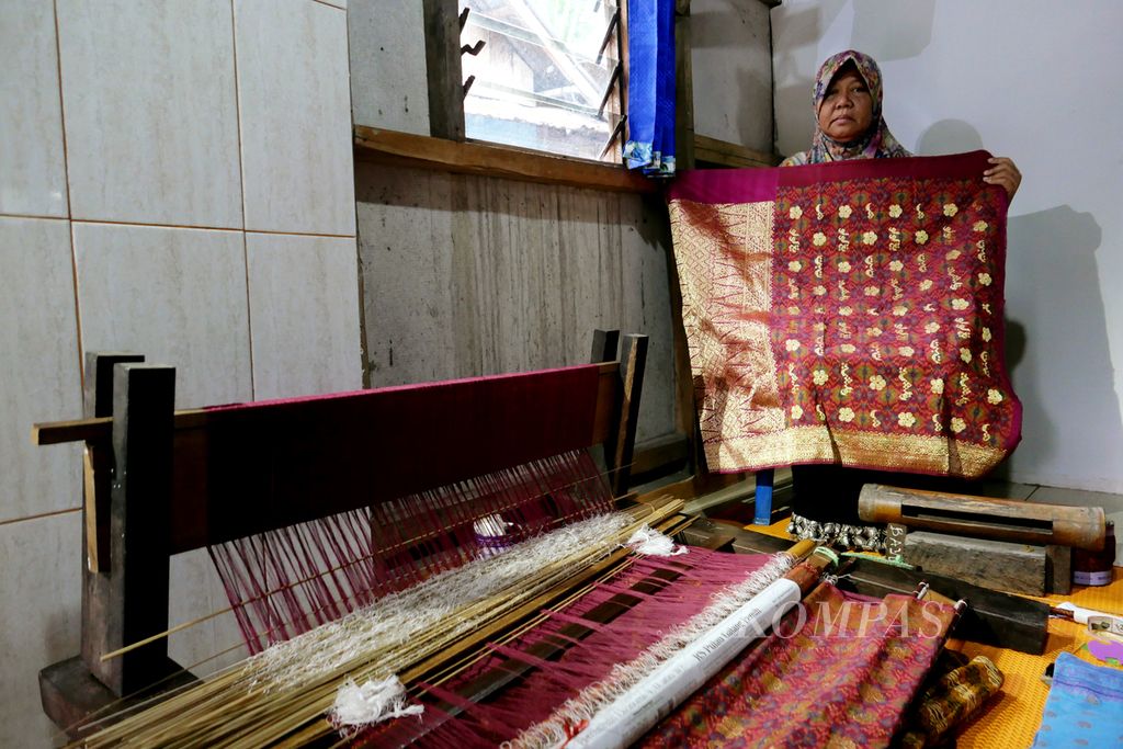 Penenun Songket Palembang, Cek Ery (54), menunjukkan songket karyanya di belakang rumahnya di kawasan Ki Gede Ing Suro, Palembang, Sumatera Selatan, Rabu (13/1/2021).