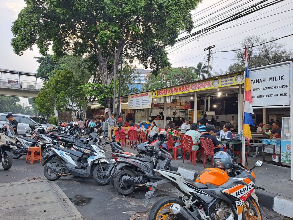  Ruas jalan menjadi tempat parkir para pengunjung lapo di dekat Kantor Pusat Badan Kepegawaian Negara, Cililitan, Jakarta Timur, pada Jumat (25/10/2024).