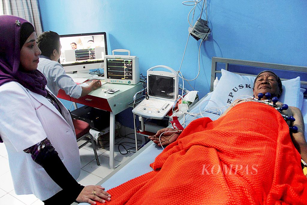 Pasien di Puskesmas Kassi-Kassi, Kota Makassar, Sulawesi Selatan, diperiksa kesehatan jantungnya oleh dokter spesialis yang terpisah jarak melalui layanan bernama tele-EKG (<i>electrocardiography</i>), Kamis (9/7). Layanan kesehatan berbasis teknologi informasi itu adalah salah satu perwujudan konsep kota cerdas atau <i>smart city</i> yang diterapkan di Makassar. 