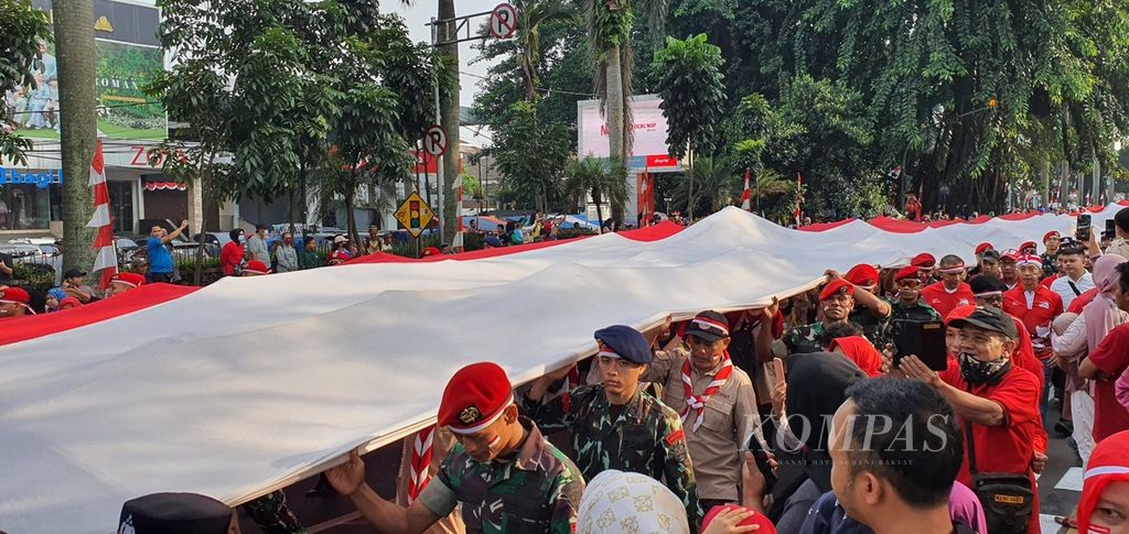Bendera merah putih berukuran 100 meter x 6 meter diarak bersama-sama sepanjang Jalan Juanda, Suryakencana, dan Siliwangi Kota Bogor, Minggu (13/8/2023). Pawai kebangsaan ini disambut meriah warga Bogor. 