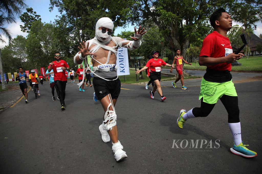Salah satu peserta Borobudur Marathon 2023 Powered by Bank Jateng mengenakan pakaian unik saat berlari di Magelang, Jawa Tengah, Minggu (18/11/2023). 