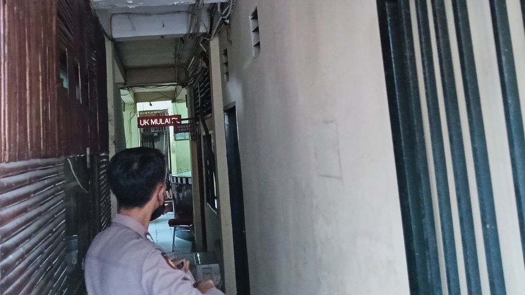 Seorang petugas polisi berjaga di depan pintu masuk rumah tahanan di Polres Metro Depok. Seorang tahanan meninggal usai dikeroyok oleh delapan narapidana di dalam rumah tahan, Sabtu (8/7/2023)