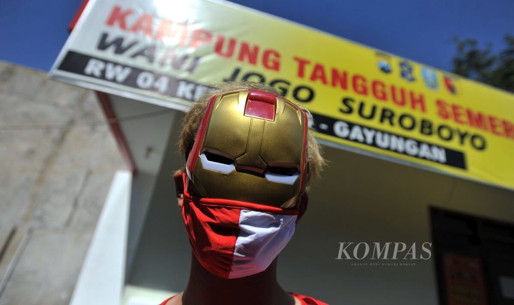 Warga RW 004 Ketintang menggunakan kostum <i>superhero </i>saat akan mengunjungi penghuni asrama mahasiswa yang sembuh dari Covid-19, di Surabaya, Jawa Timur, Jumat (10/7/2020). Kedatangan warga sebagai bentuk dukungan kepada penghuni agar selalu sehat dan tetap menjalani protokol kesehatan.