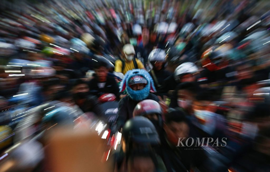 Seorang pemudik mengenakan helm kelinci terlihat di antara ribuan pemudik sepeda motor lainnya saat mengantre memasuki Pelabuhan Merak, Cilegon, Banten, Sabtu (30/4/2022) pagi.