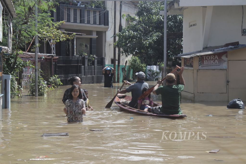 Sejumlah warga melintasi banjir di Desa Dayeuhkolot, Kecamatan Dayeuhkolot, Kabupaten Bandung, Jawa Barat, Selasa (25/5/2021). Banjir yang menggenangi sejumlah desa di Kabupaten Bandung ini merendam lebih dari 8.500 rumah dengan ketinggian hingga 150 sentimeter.