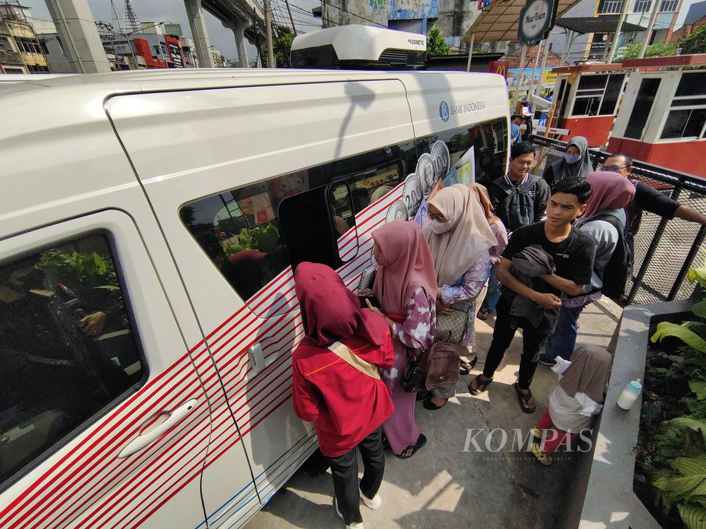 Warga mengantre untuk menukarkan uang melalui mobil kas keliling Bank Indonesia (BI) Kantor Perwakilan Sumatera Selatan di Pasar Palimo, Palembang, Sumsel, Kamis (21/3/2024).  