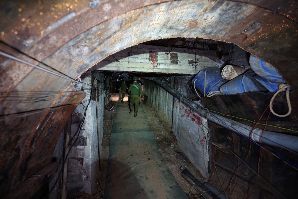  Tentara Israel di dalam terowongan Gaza di Penyeberangan Erez, 15 Desember 2023. Terowongan ini disebut sebagai pintu terowongan terbesar yang ditemukan Israel sejak serangan Hamas pada 7 Oktober 2023. 