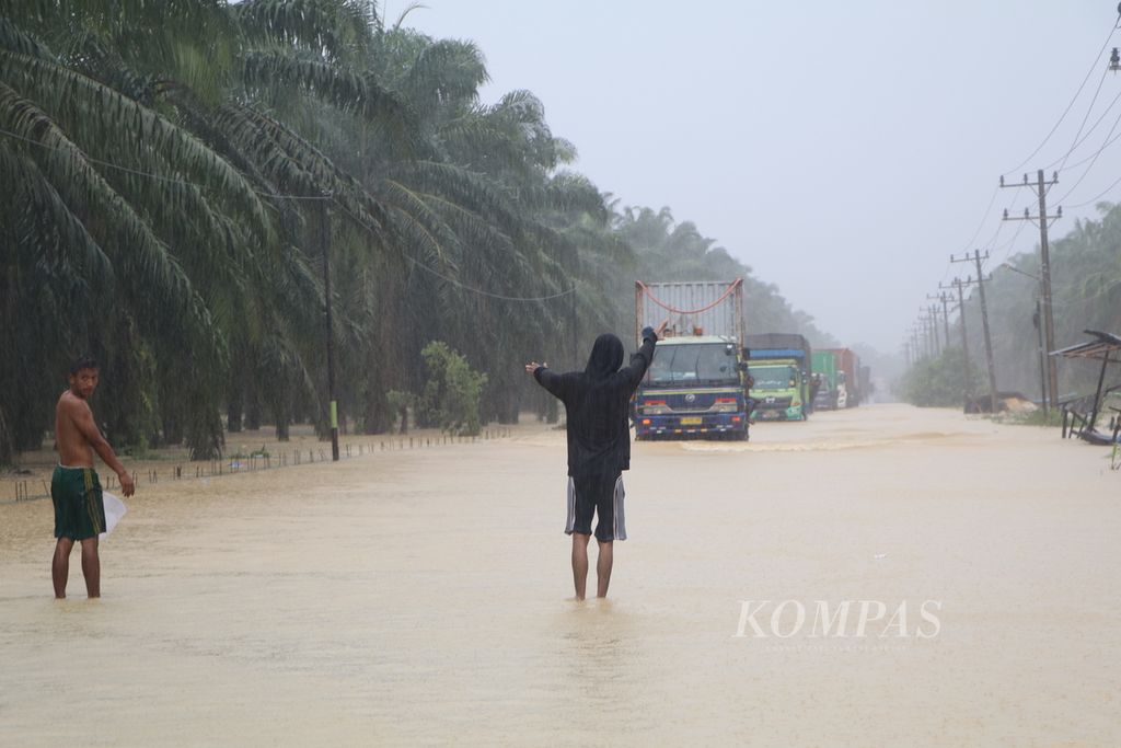 Jalan Medan-Banda Aceh sudah empat hari lumpuh karena banjir yang merendam sejumlah ruas jalan di Kabupaten Aceh Tamiang, Aceh, hingga Sabtu (5/11/2022). Ribuan kendaraan truk, bus, dan mobil pribadi sepanjang 10-15 kilometer bermalam di jalan menunggu banjir surut. Angkutan logistik Medan-Aceh pun putus total selama empat hari ini.
