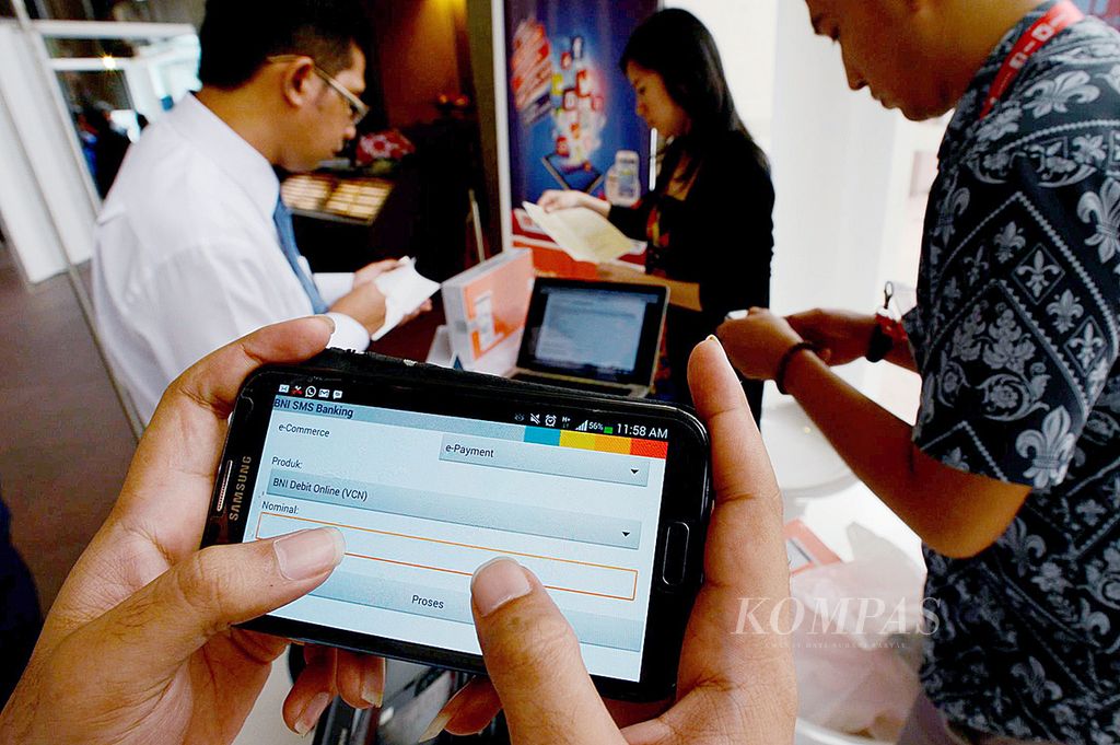 Pengunjung mencoba aplikasi belanja daring dengan sistem pembayaran menggunakan debit <i>online</i> menggunakan telepon pintar yang digelar pada Senin (10/2/2014). Masyarakat perlu meningkatkan keamanan di ponsel dengan menggunakan sandi.