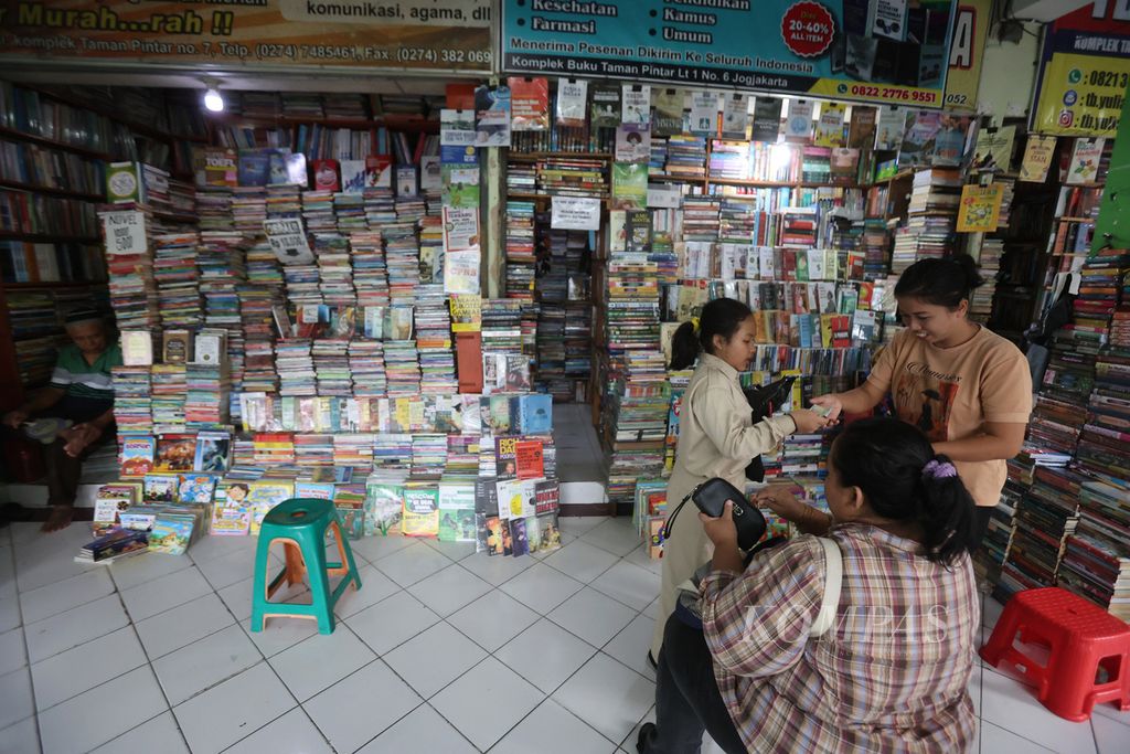 Pelajar didampingi orangtuanya membeli buku pelajaran di toko buku Taman Pintar, Yogyakarta, Rabu (13/7/2022).  