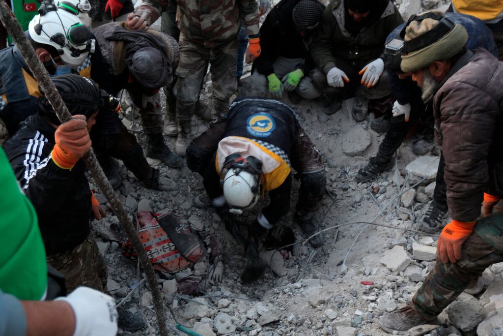 Petugas penyelamat berusaha menggali untuk menjangkau korban anak-anak yang berada di bawah reruntuhan bangunan di kota Jindayris, Suriah, Rabu 8/2/2023). 