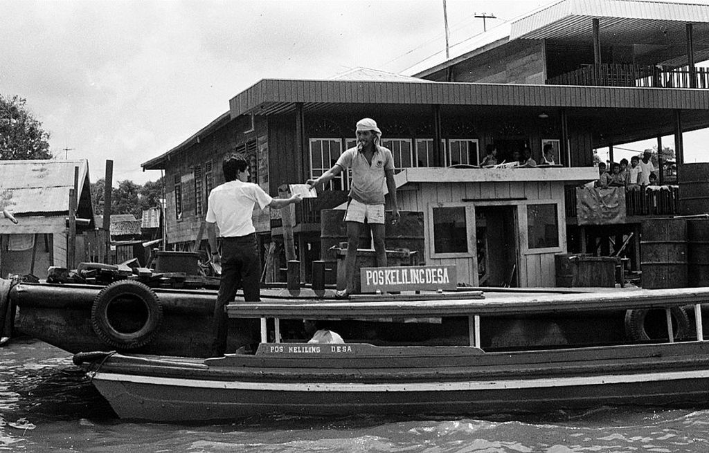 Dinas Pos Keliling melayani warga Banjarmasin, Kalimantan Selatan, yang tinggal di tepi sungai, Jumat (20/11/1987). 