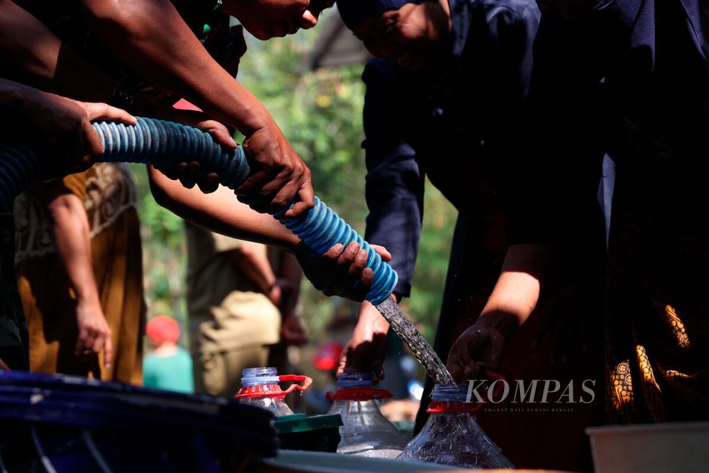 Anggota TNI dari Koramil 14/UB membagikan air dari truk tangki ke dalam wadah yang dibawa warga di Desa Kalikayen, Kecamatan Ungaran Timur, Kabupaten Semarang, Jawa Tengah, Senin (11/9/2023). 