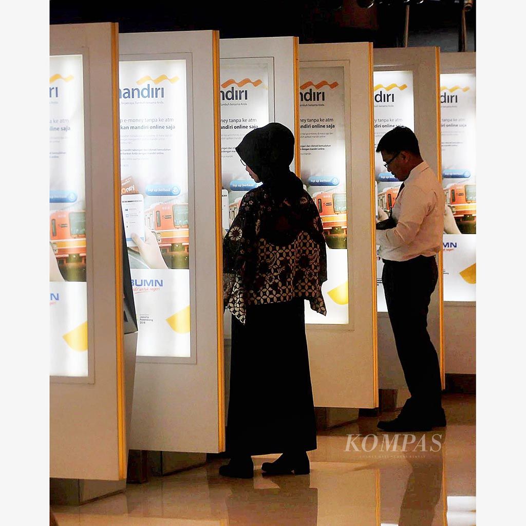 Nasabah bertransaksi melalui mesin  anjungan tunai mandiri (ATM) di Plaza Mandiri, Jakarta, Selasa (5/12). Bank Indonesia memberlakukan Gerbang Pembayaran Nasional mulai Senin lalu yang dalam tahap awal diwujudkan dalam kartu ATM dan debit dengan logo nasional untuk transaksi di dalam negeri. 