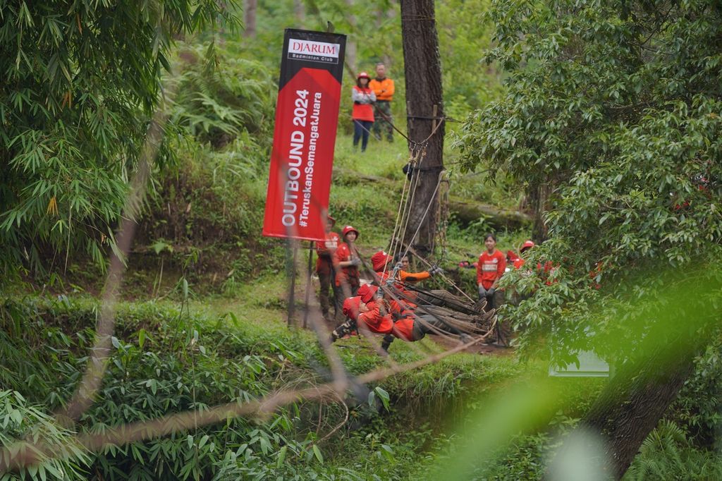 Fasilitator menggoyang-goyangkan tali untuk menantang atlet PB Djarum yang mencoba permainan jembatan dua tali dalam mancakrida (<i>outbound</i>) di hutan pinus di Lembang, Jawa Barat, Kamis (11/1/2024).