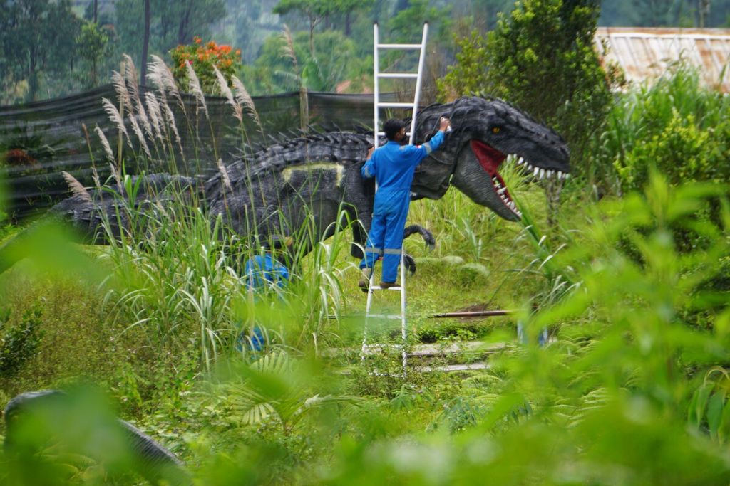 Petugas mengecat ulang patung dinosaurus di Desa Wisata Lembah Asri Serang di Kabupaten Purbalingga, Jawa Tengah, Kamis (28/4/2022).