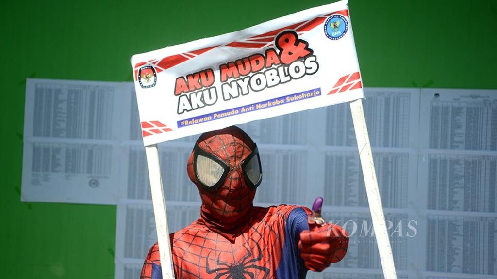 Pemilih yang menggunakan kostum tokoh pahlawan super Spiderman menunjukkan jarinya yang telah dicelupkan pada tinta setelah menggunakan hak pilihnya dalam pilkada di TPS 1, Kelurahan Gayam, Kecamatan Sukoharjo, Kabupaten Sukoharjo, Jawa Tengah, Rabu (27/6/2018). 