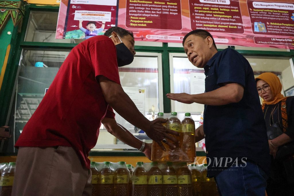 Staf Khusus Menteri Perdagangan Bidang Hubungan Antar Lembaga Syailendra (kanan) menyerahkan secara simbolis minyak goreng Minyakita kepada pedagang di Pasar Beringharjo, Yogyakarta, Kamis (16/2/2023). 