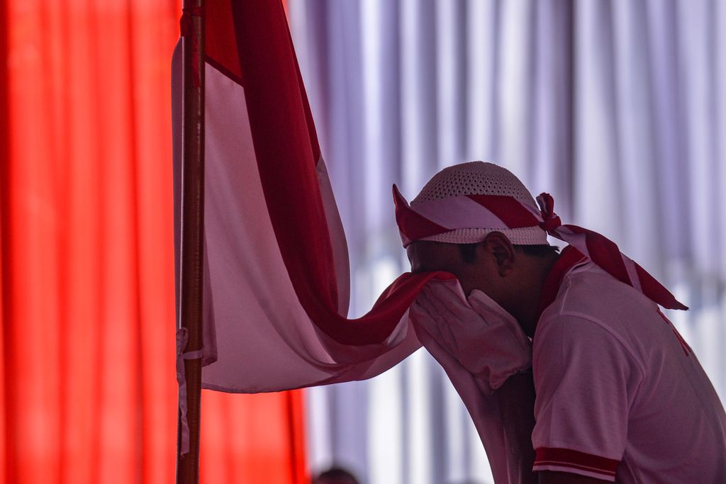 Seorang tahanan kasus terorisme mencium Bendera Merah Putih setelah pembacaan ikrar setia kepada Negara Kesatuan Republik Indonesia (NKRI) di Lapas Narkotika Kelas IIA Gunung Sindur, Kabupaten Bogor, Kamis (1/6/2023). 