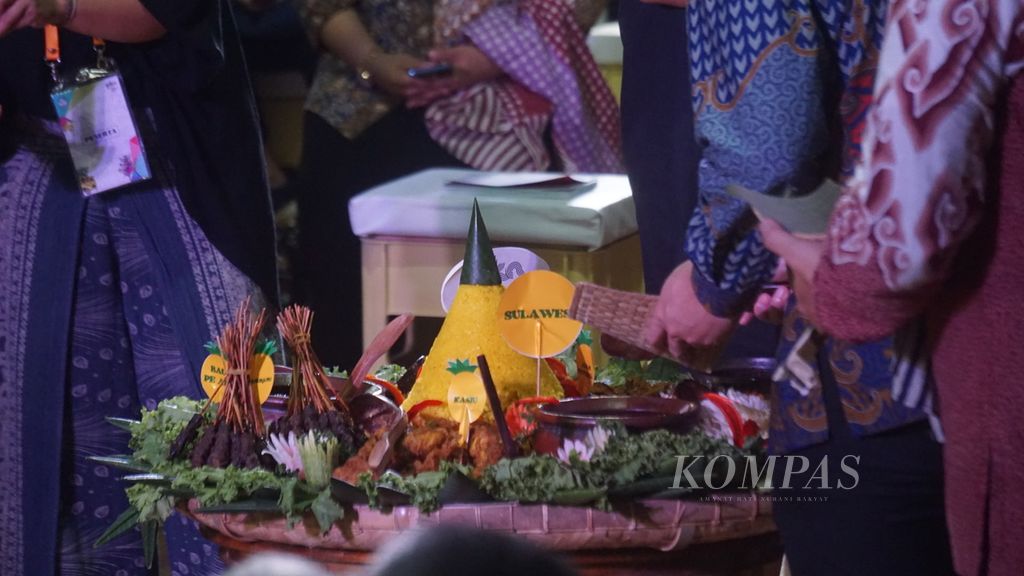 Proses pengambilan tumpeng dengan cara dikeruk dari bawah saat peresmian puncak perayaan Pekan Kebudayaan Nasional tahun 2023 di Galeri Nasional, Jakarta, Jumat (20/10/2023).