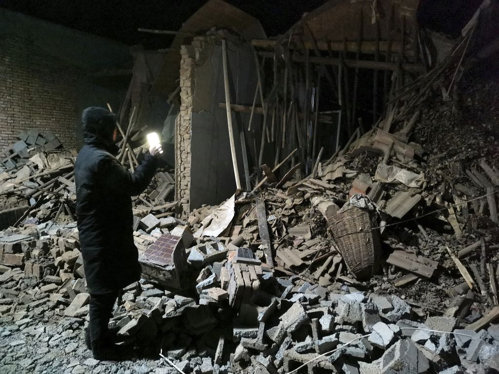 Pegawai pemerintah memeriksa reruntuhan rumah yang ambruk karena gempa di Kabupaten Jishishan di Provinsi Gansu, China, Selasa (19/12/2023) . 