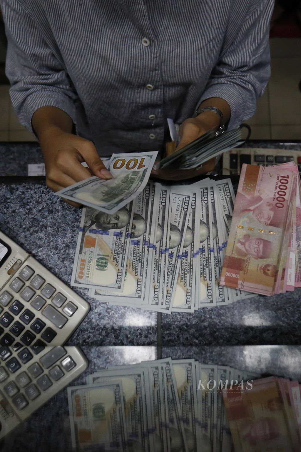 Pegawai perusahaan penukaran uang asing di ITC Kuningan, Jakarta Selatan, menghitung dan melihat kondisi lembaran uang dollar AS, Senin (7/8/2023). Berdasarkan kurs referensi Jakarta Interbank Spot Dollar Rate (Jisdor), nilai tukar rupiah Rp 15.178 per dollar AS. 