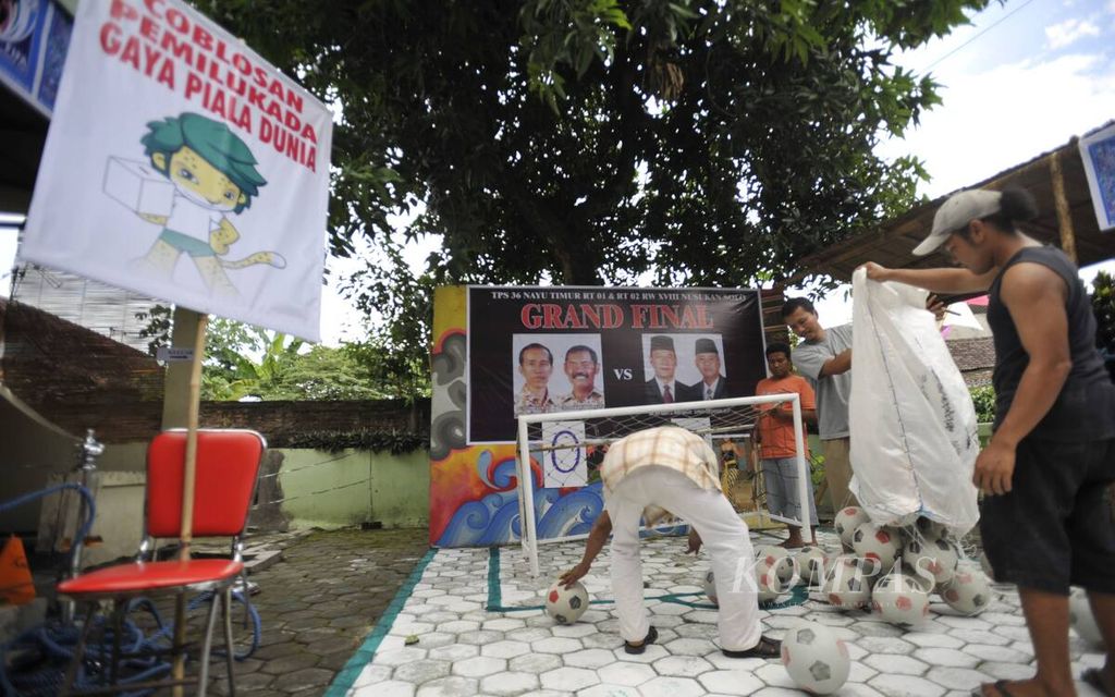 Warga bergotong royong membangun tempat pemungutan suara (TPS) pemilihan wali kota dengan nuansa sepak bola dan Piala Dunia di TPS 36 Nayu Timur, Kelurahan Nusukan, Kota Surakarta, Minggu (25/4/2010).