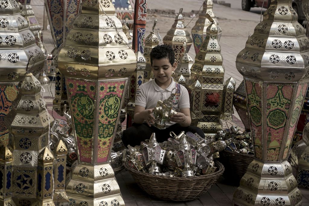 Seorang anak laki-laki membeli lentera tradisional menjelang bulan puasa Ramadhan yang akan datang, di Kairo, Mesir,  7 Maret 2024.