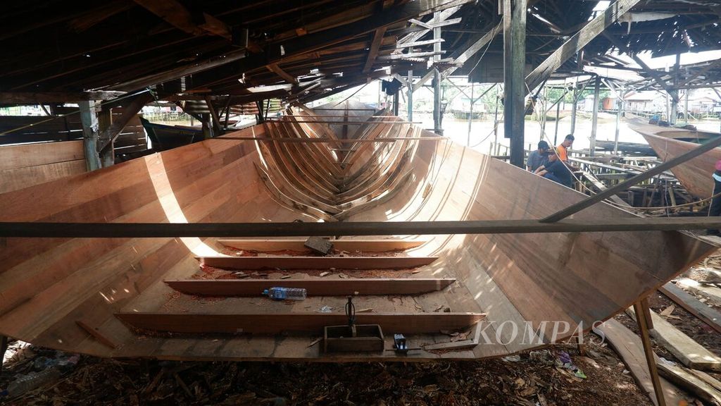 Calon pembeli memperhatikan proses pembuatan perahu di Desa Pulau Sewangi, Kecamatan Alalak, Kabupaten Barito Kuala, Kalimantan Selatan, Sabtu (9/3/2024). 