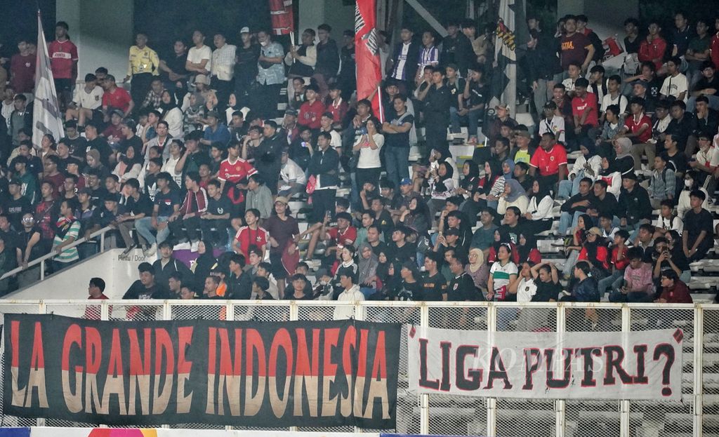 Suporter Timnas Putri Indonesia membentangkan spanduk mempertanyakan Liga Putri Indonesia dalam laga persahabatan antara Timnas Putri Indonesia dan Timnas Putri Singapura di Stadion Madya Kompleks Gelora Bung Karno, Jakarta, sebelum diminta dilepas oleh panitia pertandingan, Selasa (28/5/2024).