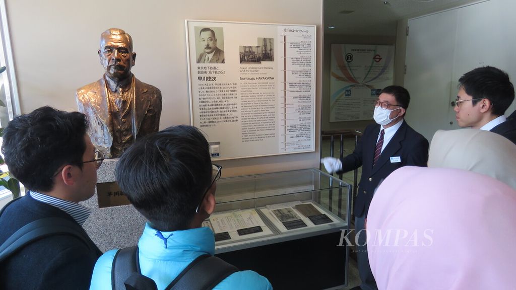 Manajer Metro Museum Koichi Okubo (kanan depan, bermasker) menjelaskan peran Noritsugu Hayakawa dalam pembangunan sistem kereta bawah tanah (<i>subway</i>) di Tokyo, Jepang, Selasa (14/11/2023). Patung Hayakawa juga dipajang sebagai penghormatan. 