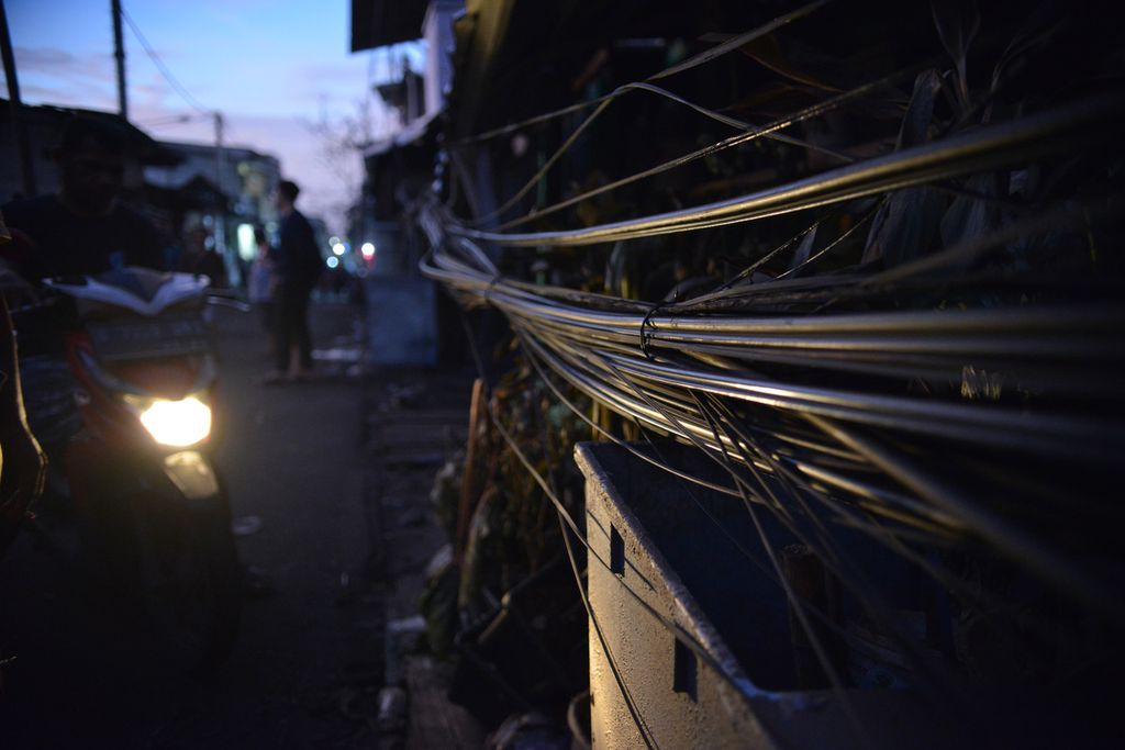 Salah satu deretan kabel listrik yang menjuntai di Jalan Tanah Merah Bawah, Rawa Badak Selatan, Koja, Jakarta Utara, Minggu (5/3/2023). 